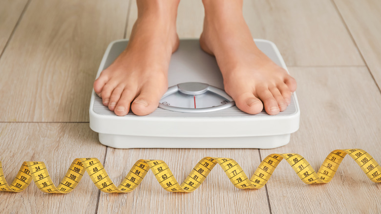 woman checking weight on scale
