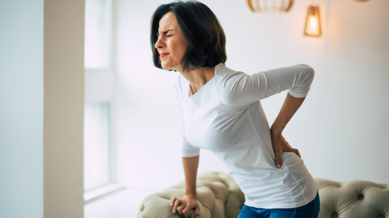 woman holding her back in pain