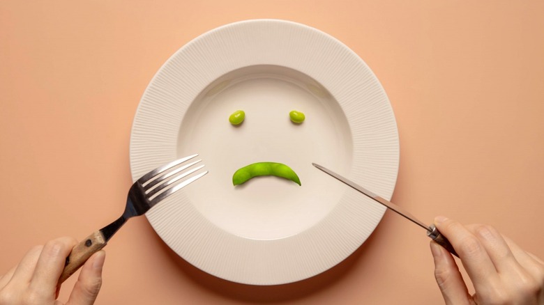 Sad face of peas on plate