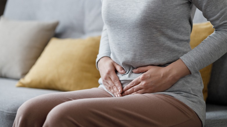 woman holding pelvic area