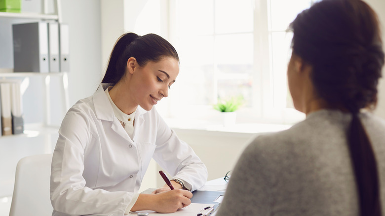 Young woman doctor with patient 