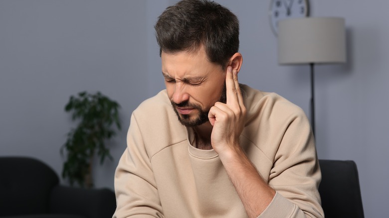 man holding his ear