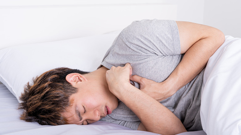 a young man wakes up with heartburn