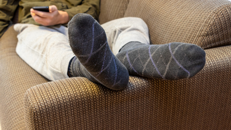 Man on a sofa with his feet elevated in socks