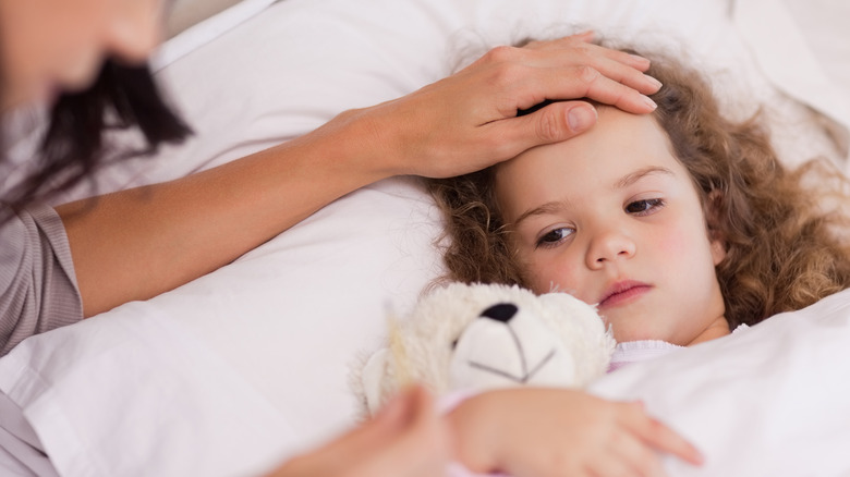 Mother with sick child in bed