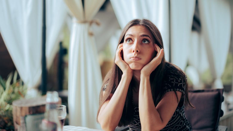 a woman looks bored while waiting 