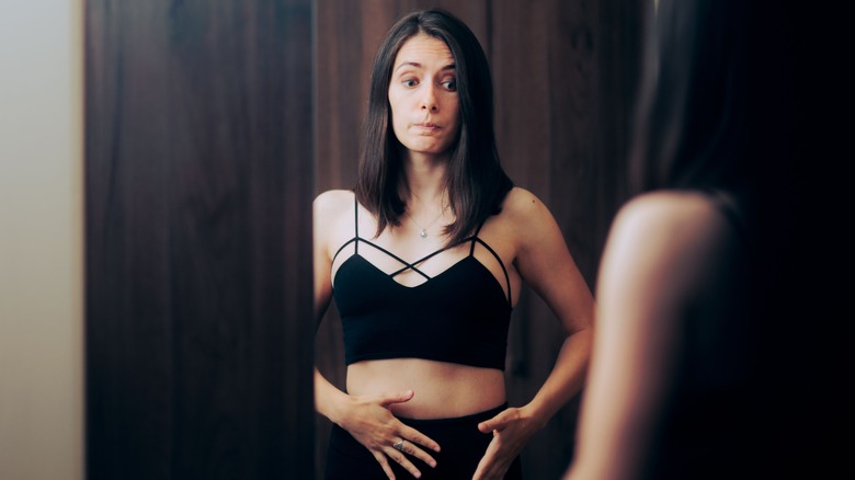 woman staring into mirror