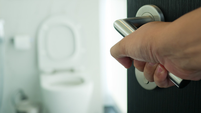 person preparing to enter the bathroom