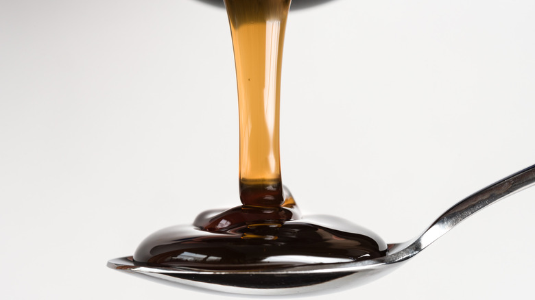 Pouring dark corn syrup on a spoon