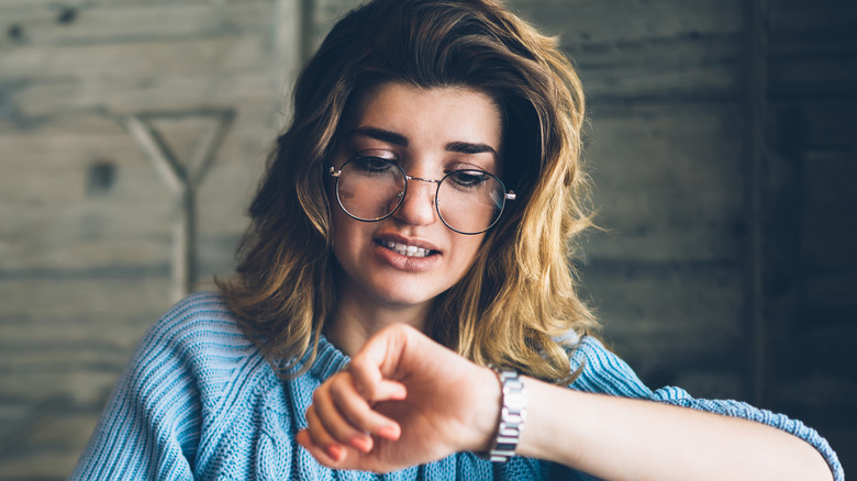 Woman working and checking the time on her watch