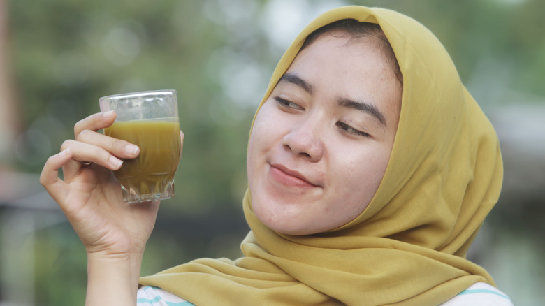 Woman holding Jamu juice