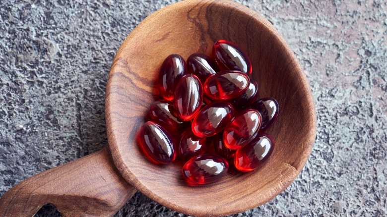 Krill oil softgels in a wooden tablespoon 