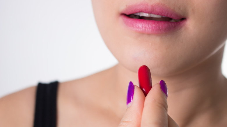Woman taking krill oil capsule