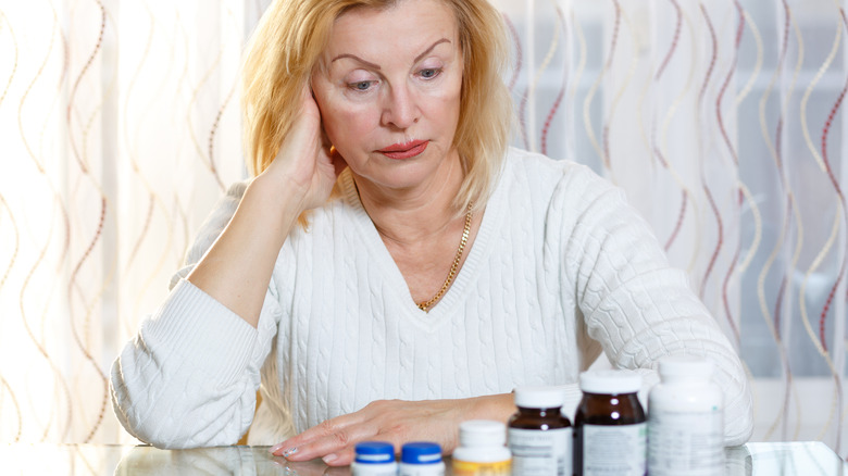 woman looking at vitamins with confused expression
