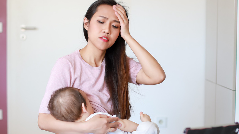 mom in pain breastfeeding baby