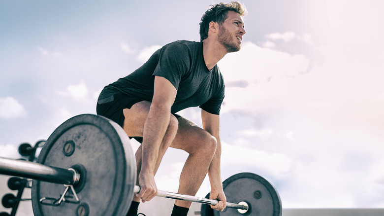 man doing a deadlift outdoors