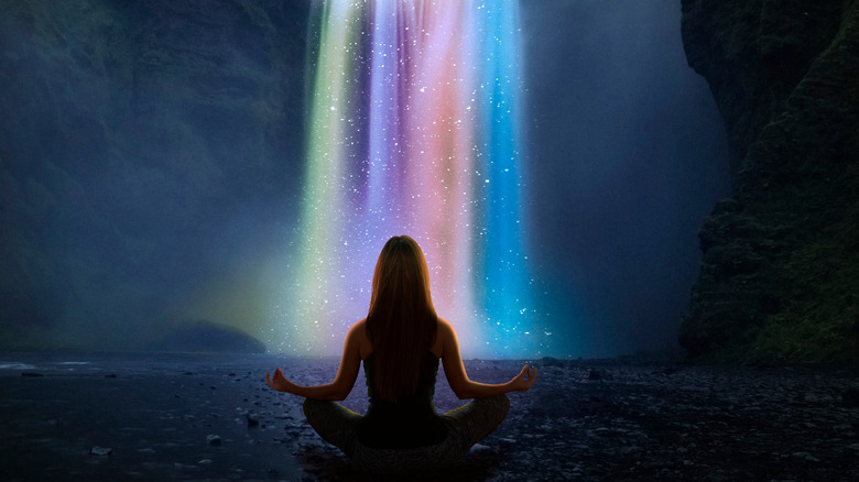 Magical realism image of a woman doing yoga in front of a waterfall