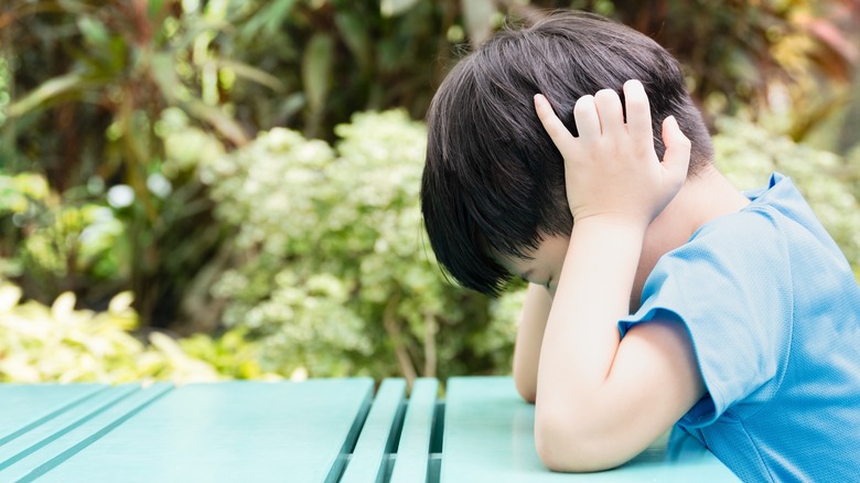 Autistic boy covering ears