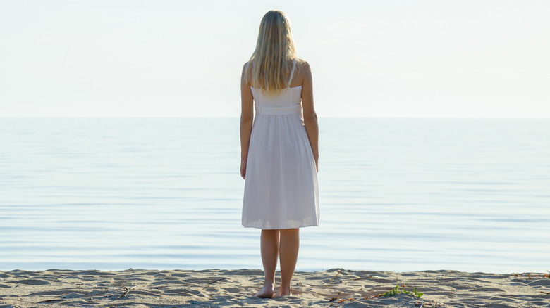 woman looking at ocean alone