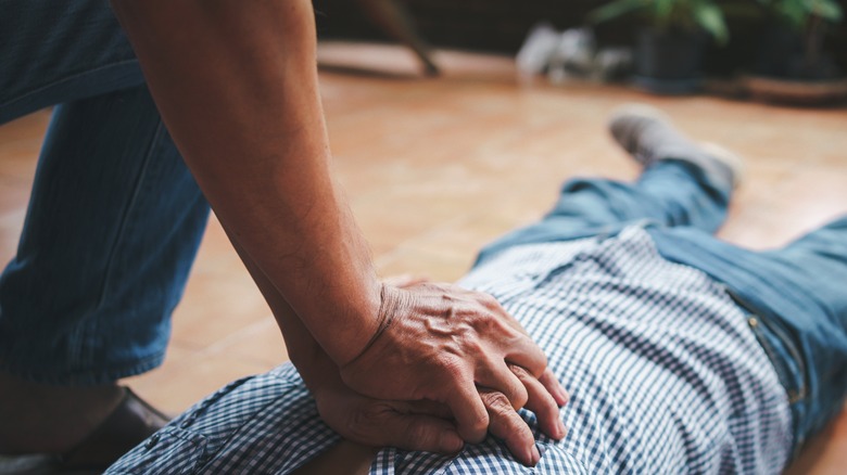 Hands administering chest compressions