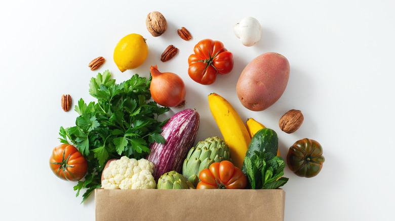 paper bag of groceries spilling out healthy foods