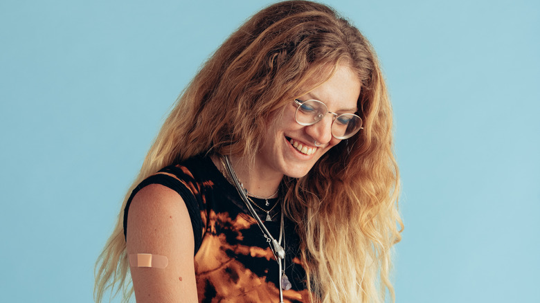woman smiling with band-aid on arm