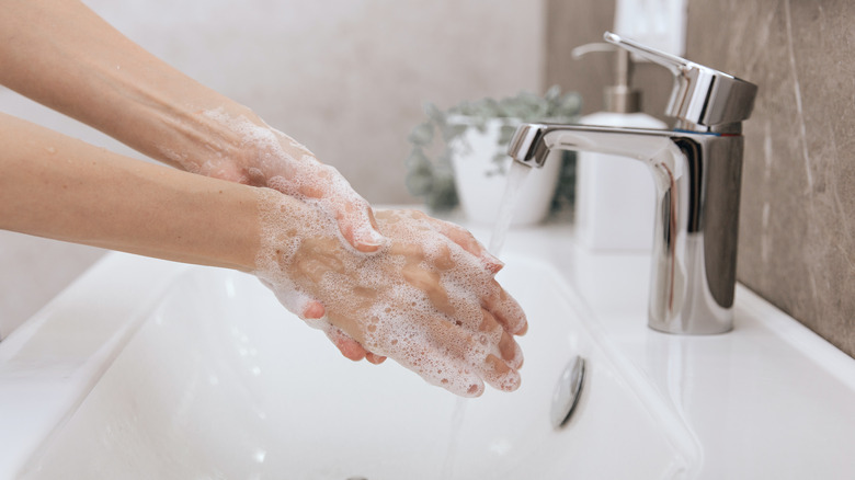 man with eczema scratches hand