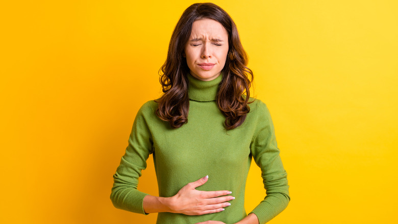 woman painfully touching stomach