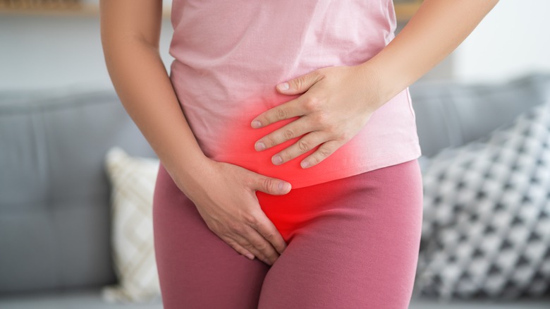 woman holding pelvic area