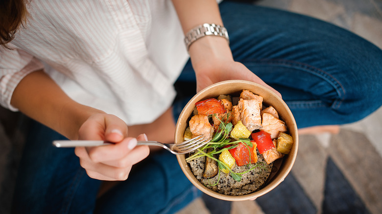 Woman sitting on the floor with bowl of healthy food