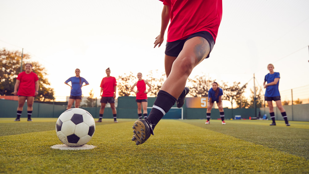 Woman kicking soccer ball