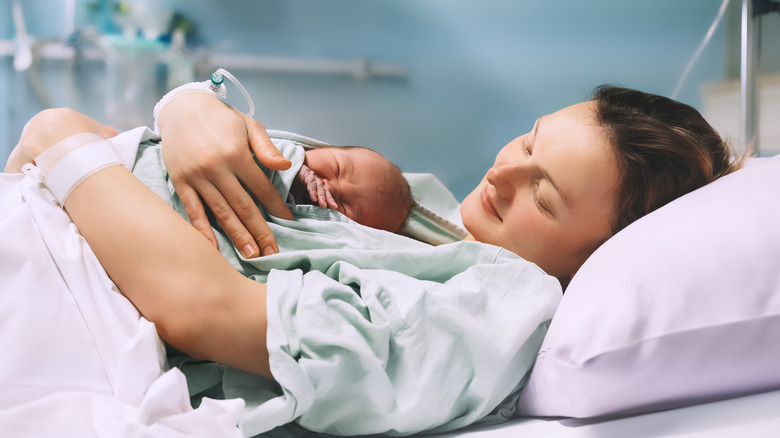 mother hugging newborn childbirth 