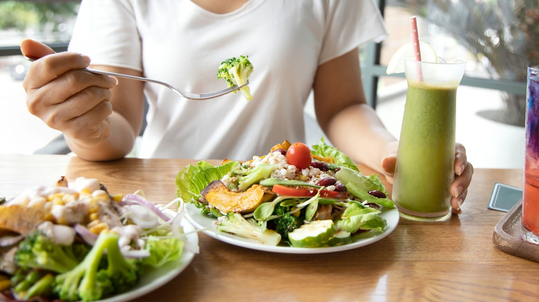 A shot of a woman eating a flavorful salad