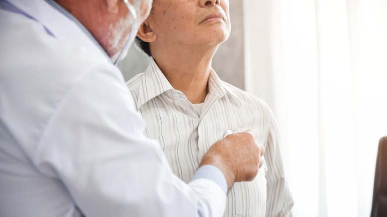 Doctor using stethoscope on patient