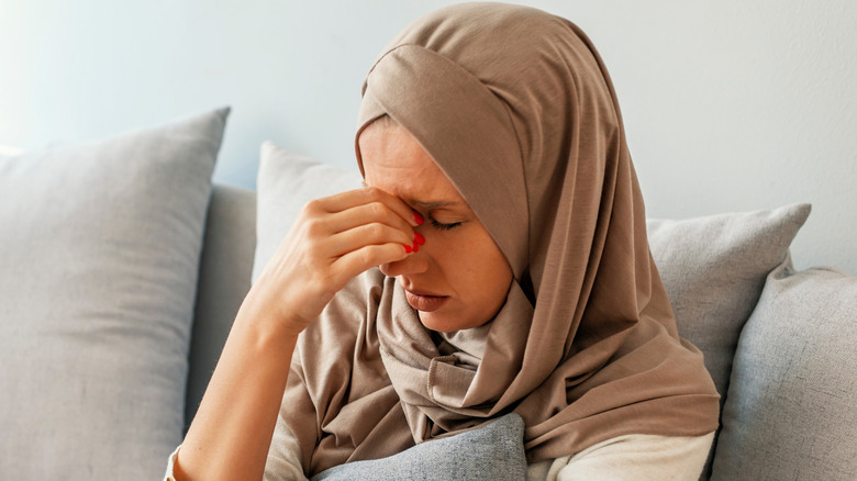 Woman with headache touching her face