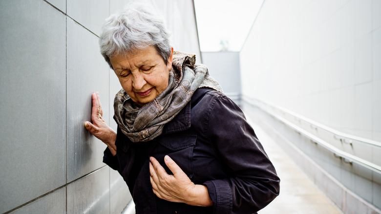 Woman steadying herself against wall