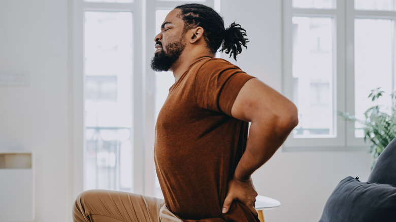 Man holding lower back in pain