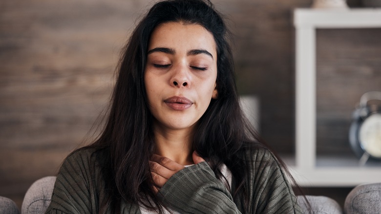 Stressed woman holding throat