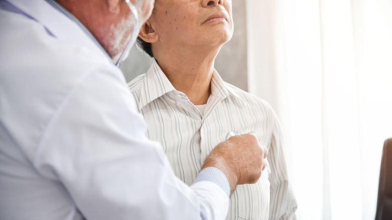 Doctor using stethoscope on patient