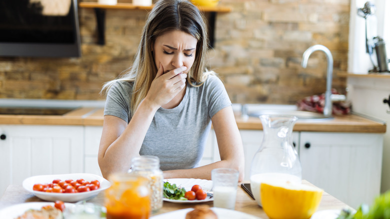 woman feeling sick at dinner table