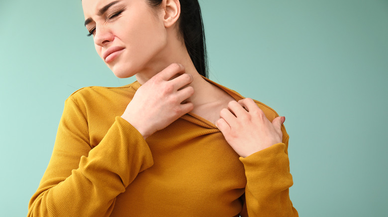 Woman itching from allergic reaction 