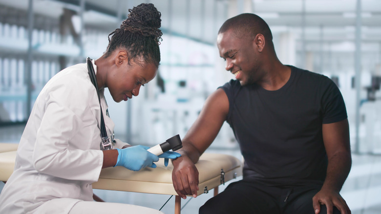 A man getting his skin screened by a doctor