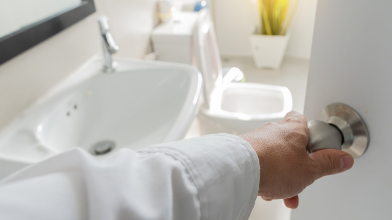Hand opening bathroom door