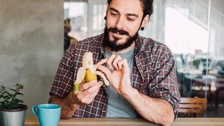 man peeling a banana