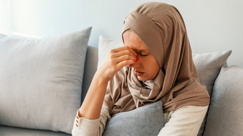 Woman with headache touching her face 