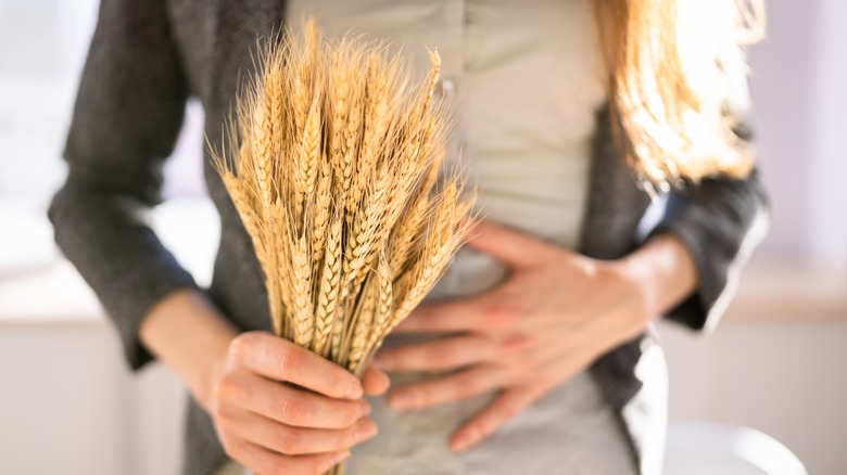 Pair of hands holding wheat and stomach