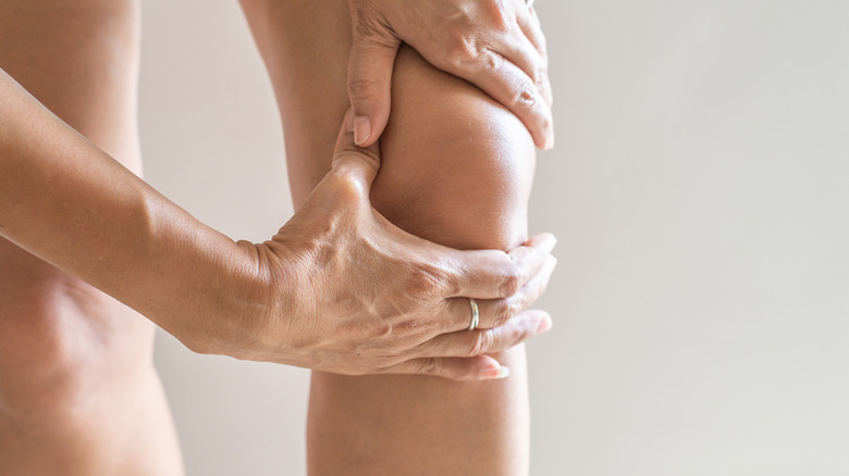 person holding knee with hands