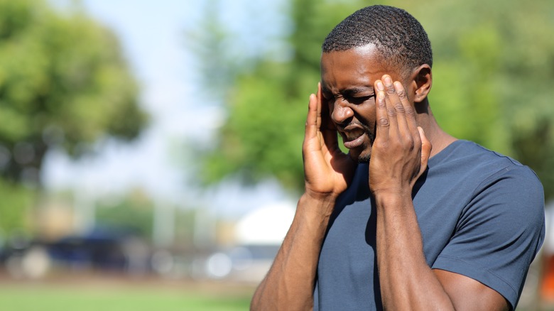 man holding temples in pain