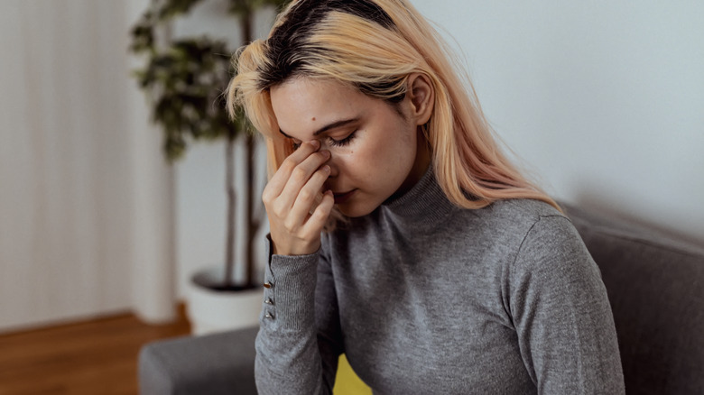 woman holding her nose bridge