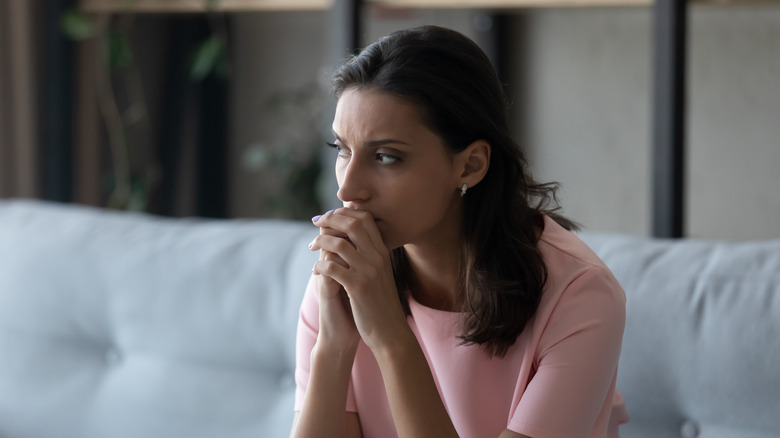 Anxious woman sitting on couch